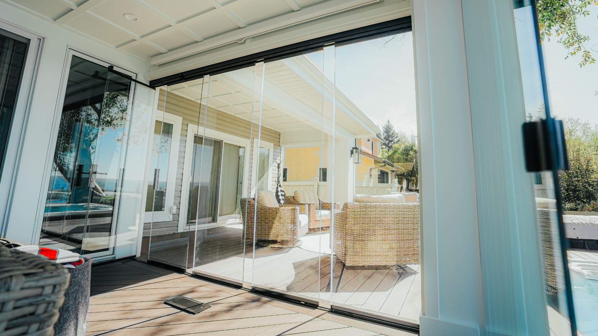 Frameless glass panels stacked open onto the deck