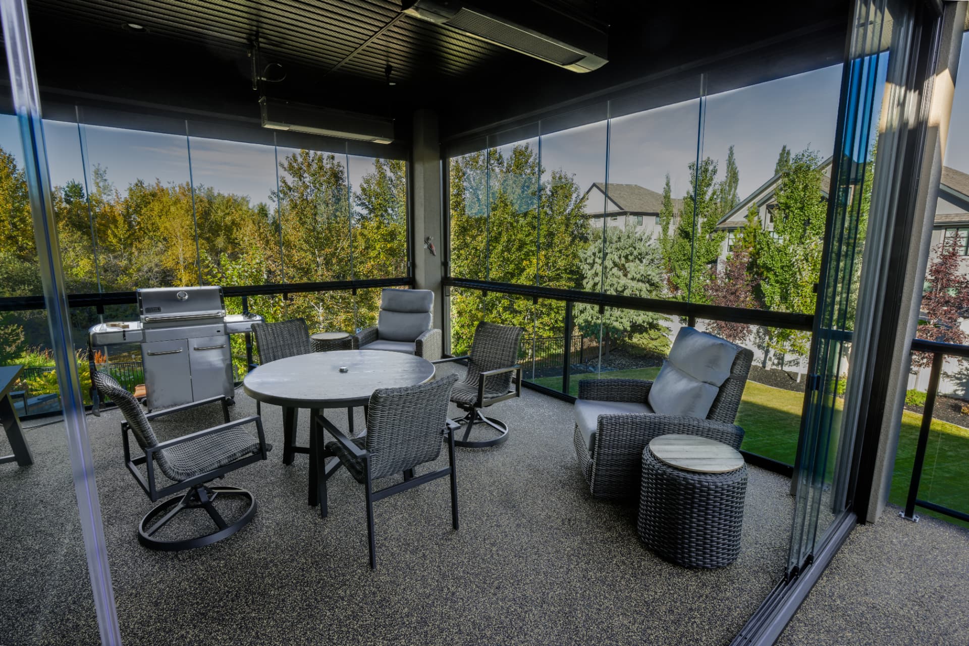 Glazed balcony interior with overhead heaters, barbecue and seating
