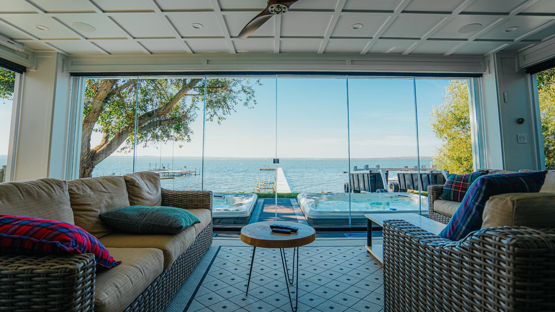 Lakeside sunroom interior with retractable glass walls overlooking the water