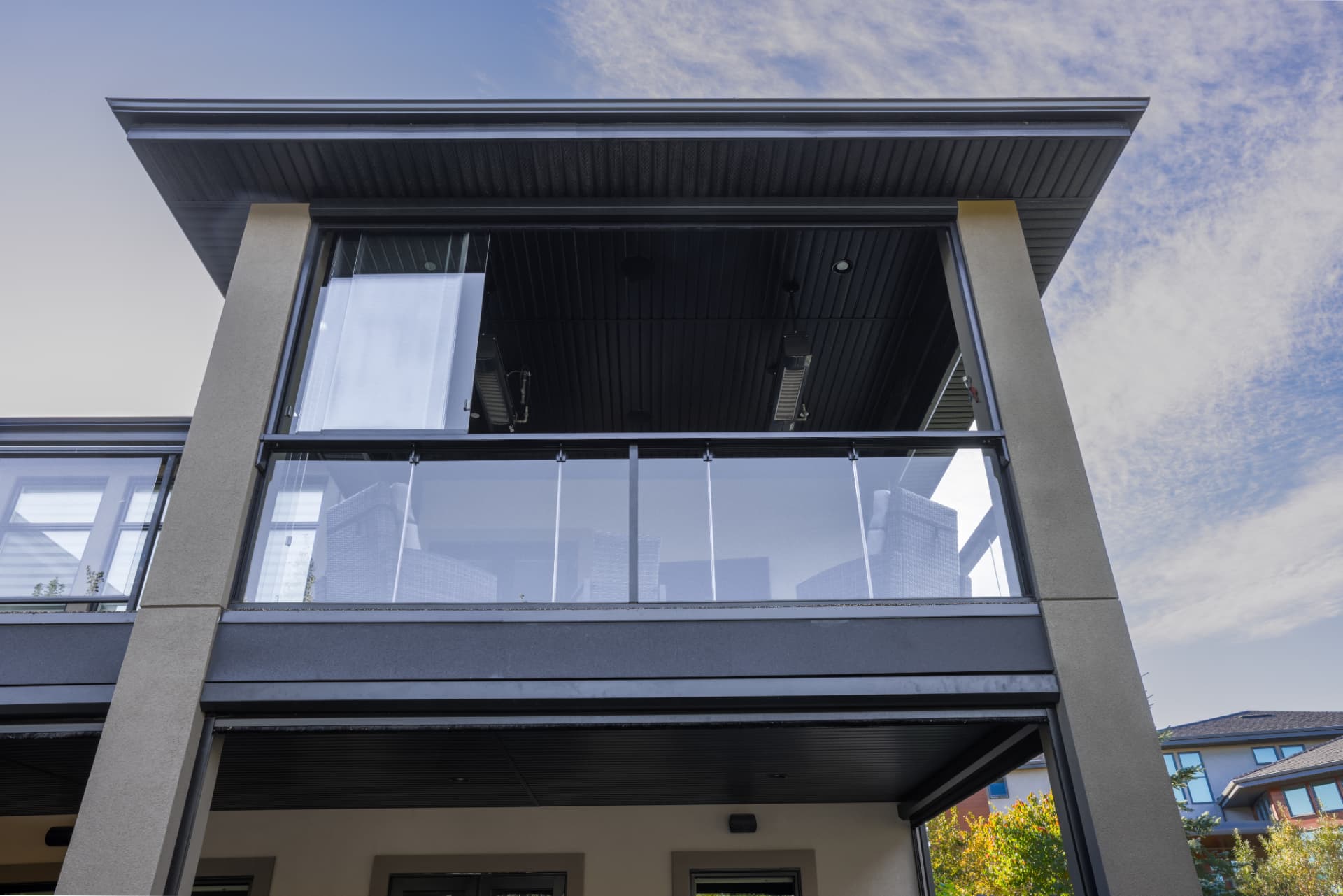 Retractable glass panels stacked open under the balcony roof
